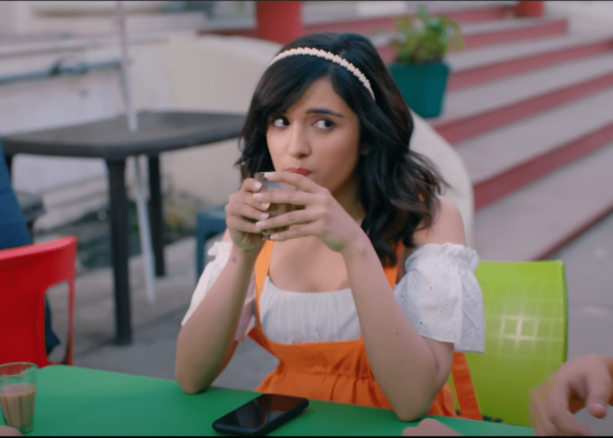 Shirley Setia sitting on a chair and drinking tea 