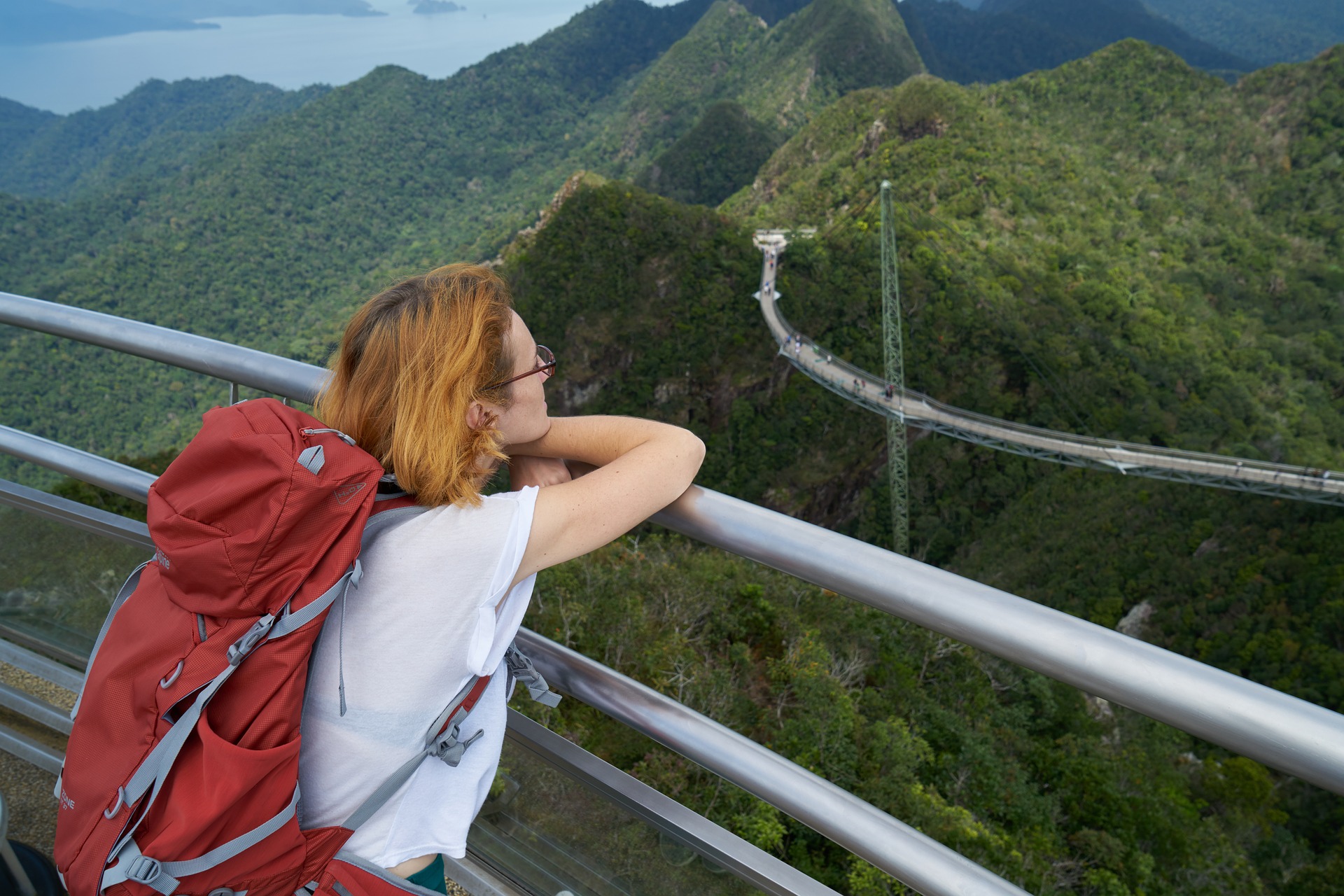 A female backpacker glaring green mountains