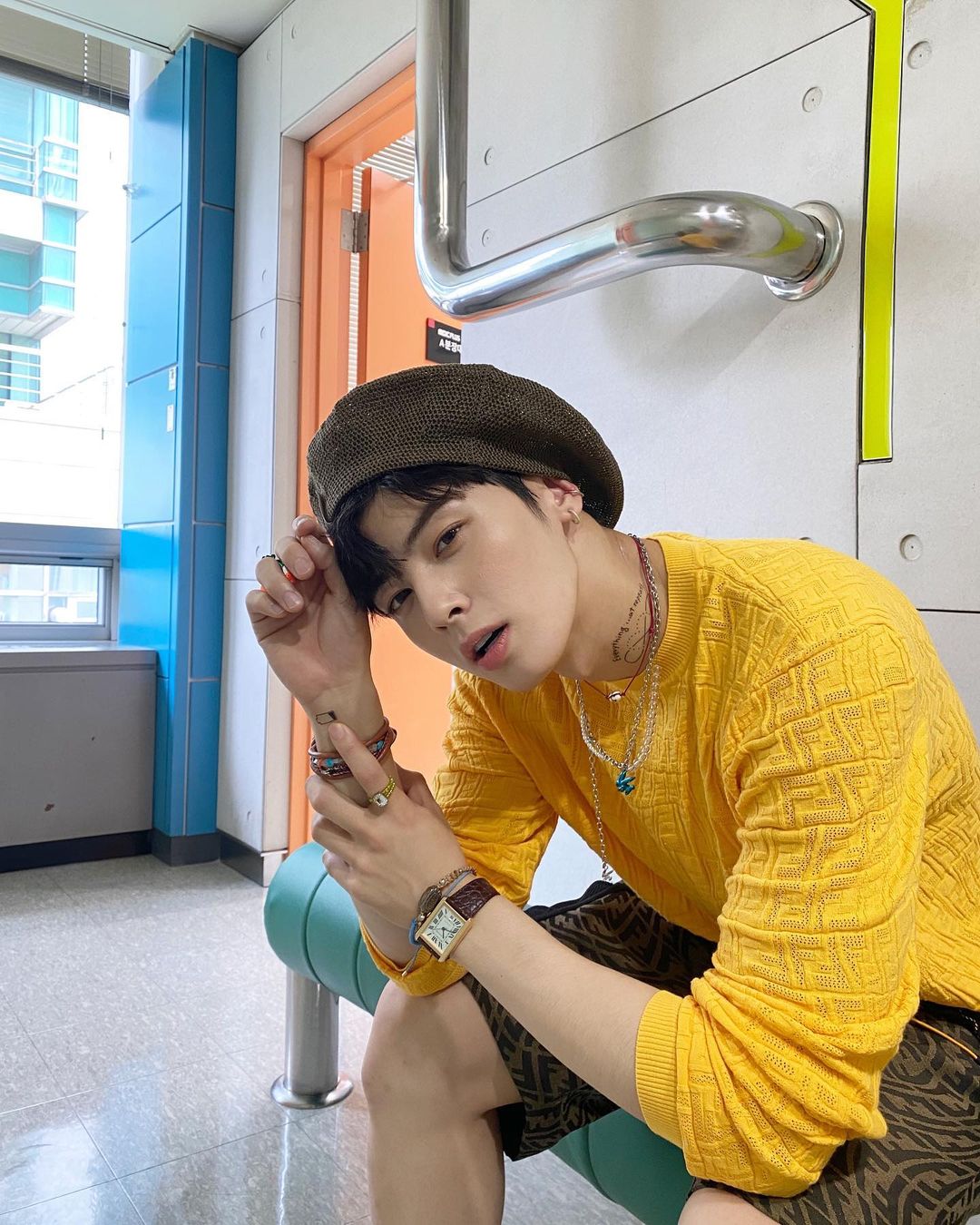 Cha Eun Woo in yellow t-shirt with a brown cap