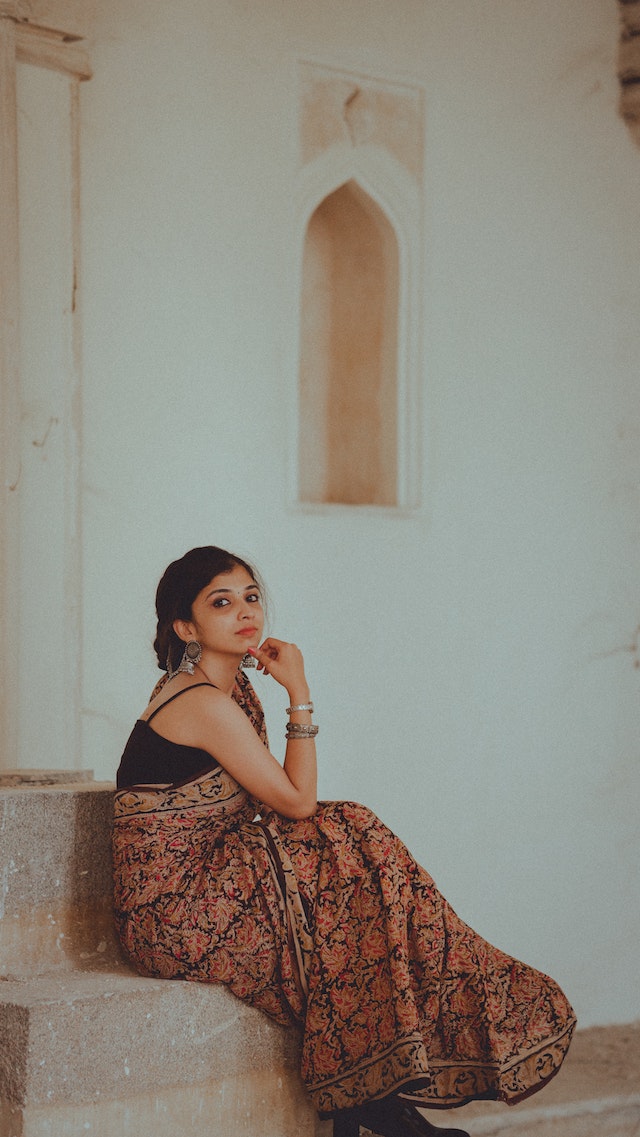 Woman in saree sitting on stairs