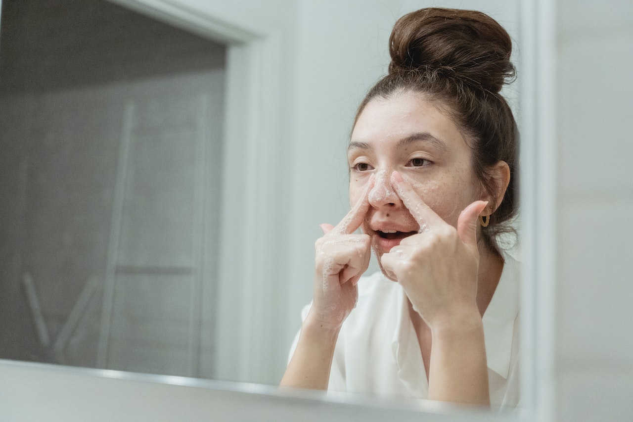 Woman Applying Face Wash on her face