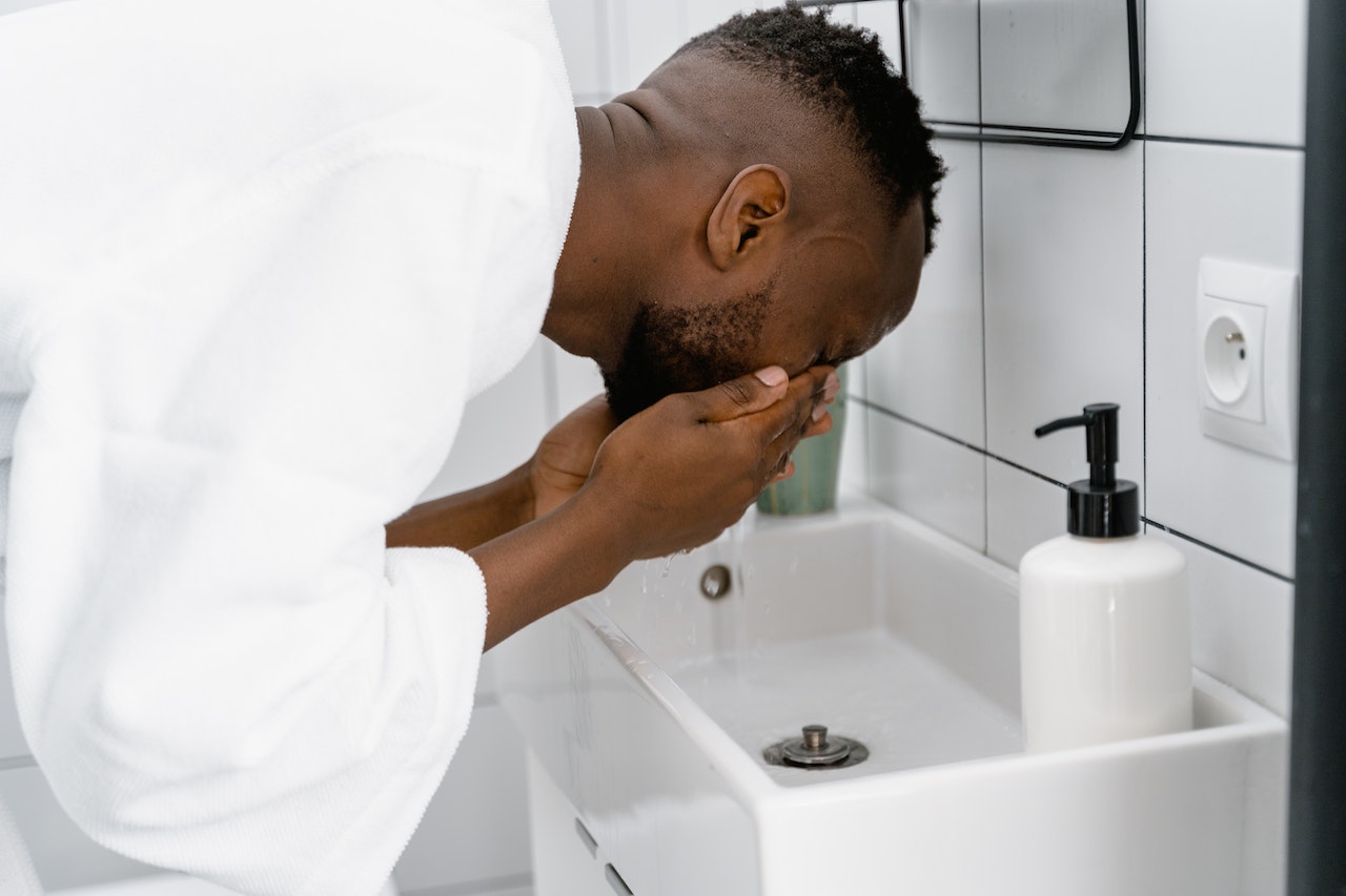 Man using face wash to clean his face