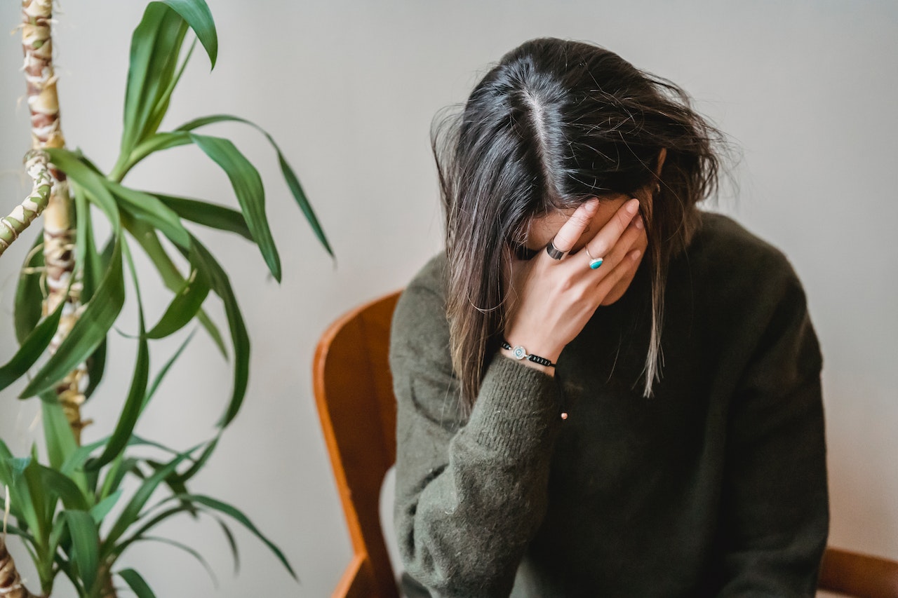 Anxious young woman covering face with hand