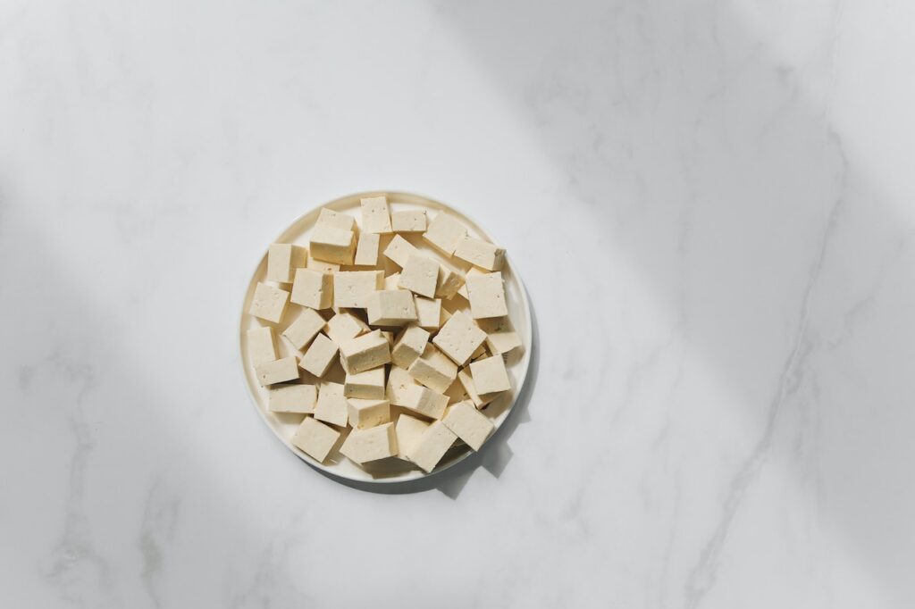 Tofu pieces in plate on white background