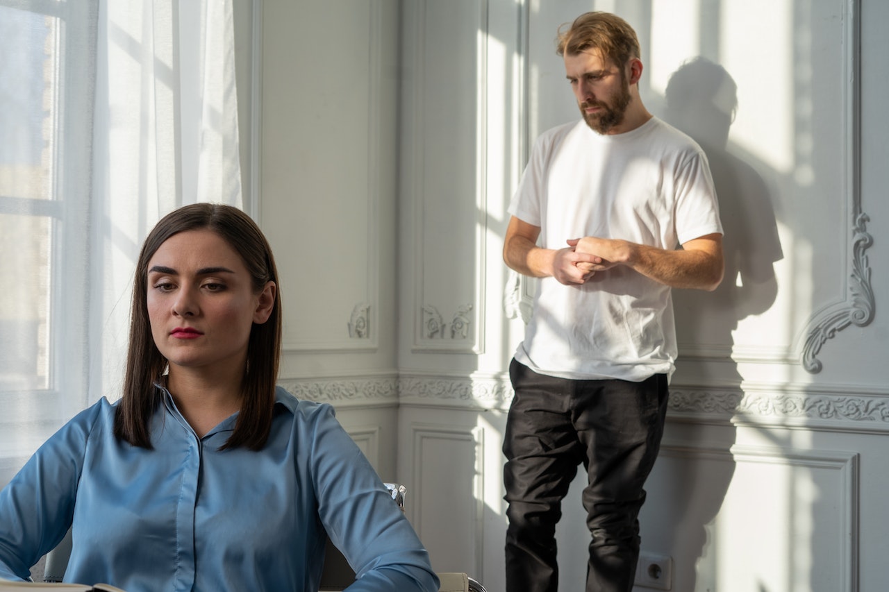 Man standing behind woman after relationship conflict